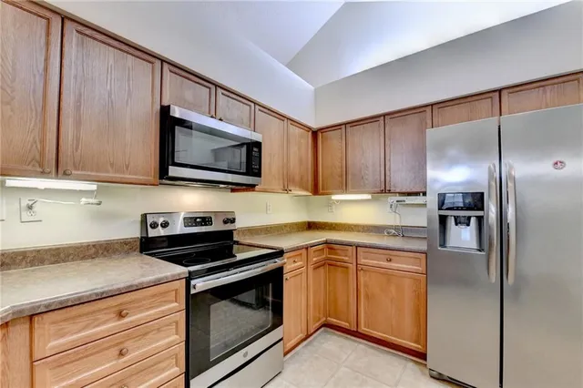 an empty room with wooden floor chandelier fan and windows