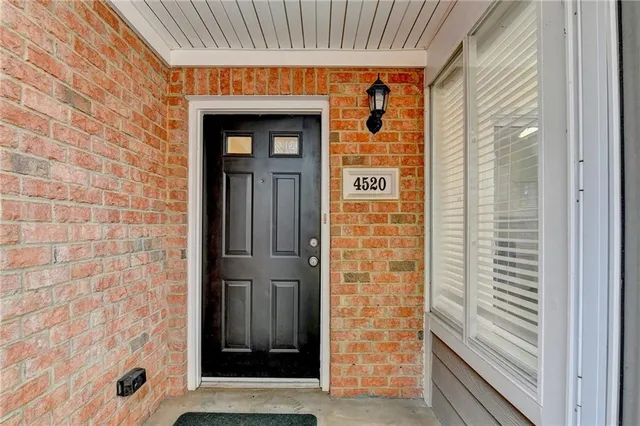 an empty room with windows fireplace and wooden floor