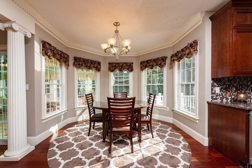 63 Bridge Street Raynham, MA 02767 - Photo 14 of 38 a dining room with wooden floor a chandelier a wooden table and chairs