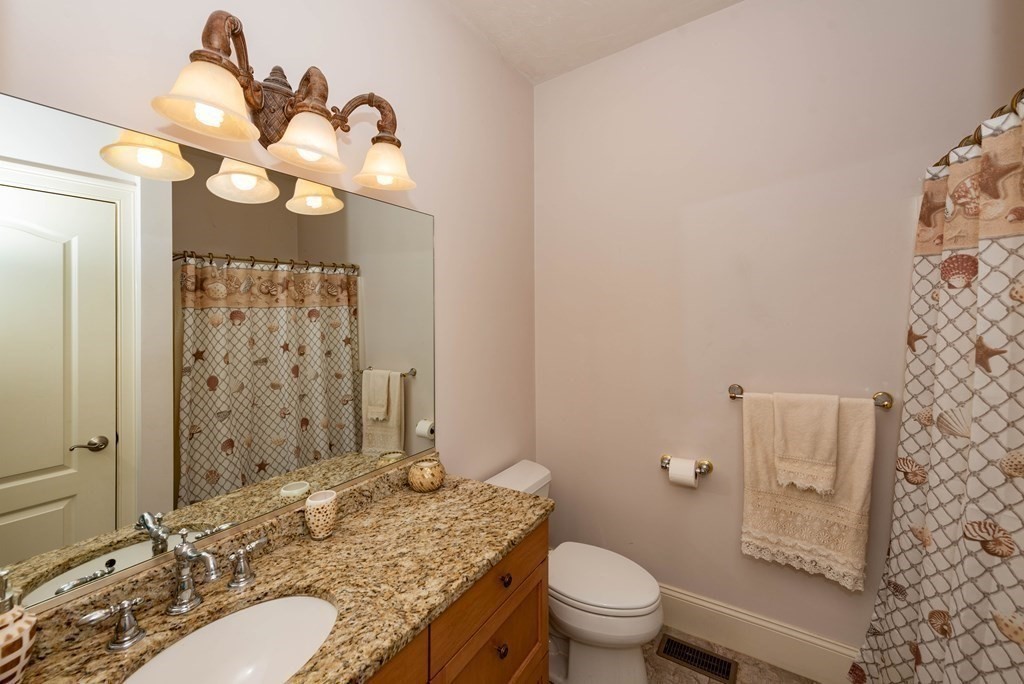 63 Bridge Street Raynham, MA 02767 - Photo 25 of 38 a bathroom with a granite countertop toilet sink and mirror