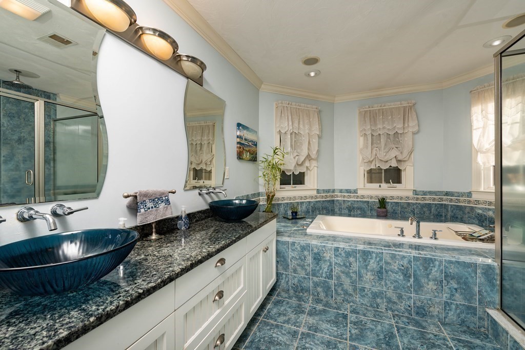 63 Bridge Street Raynham, MA 02767 - Photo 34 of 38 a bathroom with double vanity sinks double vanity tub and a mirror