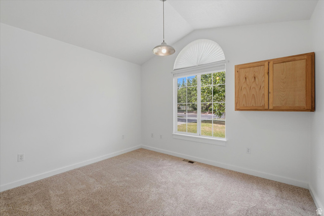791 East Saddle Road Grantsville, UT 84029 - Photo 24 of 46 Vaulted ceiling room featuring a large arched window with horizontal blinds, neutral carpet flooring, and a wall-mounted wooden storage cabinet