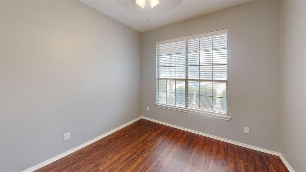 14308 Polo Ranch Street Fort Worth, TX 76052 - Photo 14 of 19 Room featuring wood-finish flooring, light grey walls, and a large window with horizontal blinds