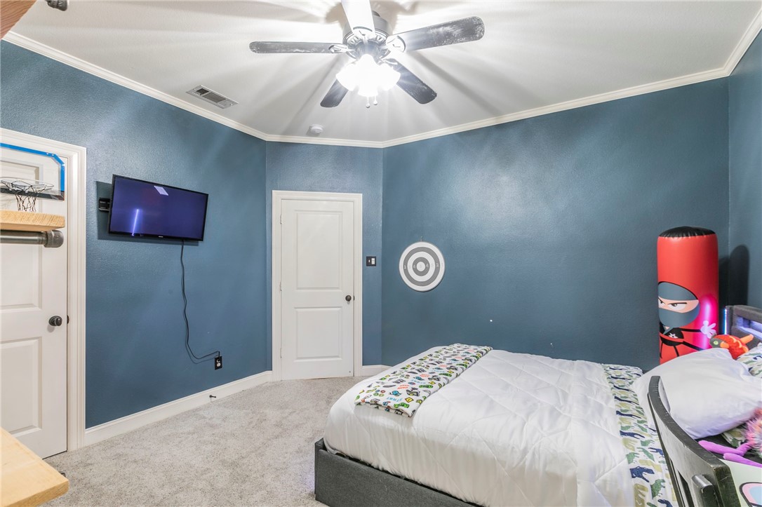 1031 Briar Glen Circle McGregor, TX 76657 - Photo 28 of 41 a bedroom with a bed and a chandelier