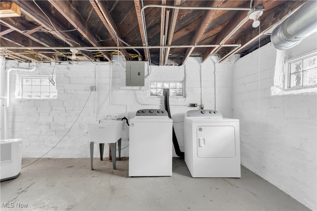 945 Nela View Road Cleveland Heights, OH 44112 - Photo 23 of 27 Laundry room with healthy amount of natural light, concrete flooring, washing machine and clothes dryer, and electric panel