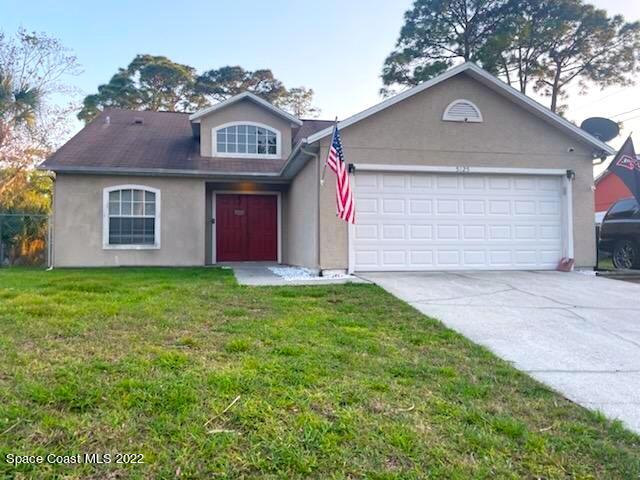 a front view of a house with a garden and garage