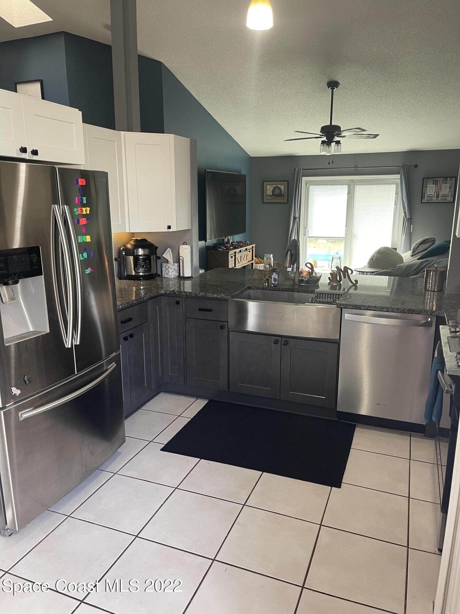 5125 Holden Road Cocoa, FL 32927 - Photo 3 of 6 a kitchen with stainless steel appliances a sink stove and refrigerator