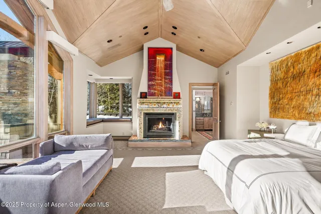 a living room with furniture a flat screen tv and a floor to ceiling window