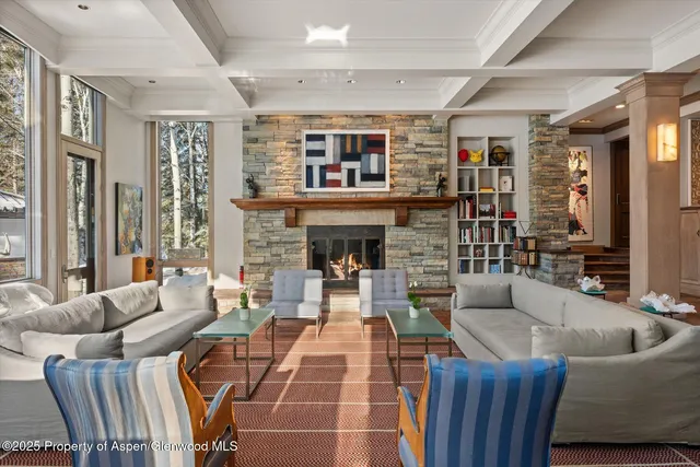 a living room with furniture a dining table wooden floor and a large window