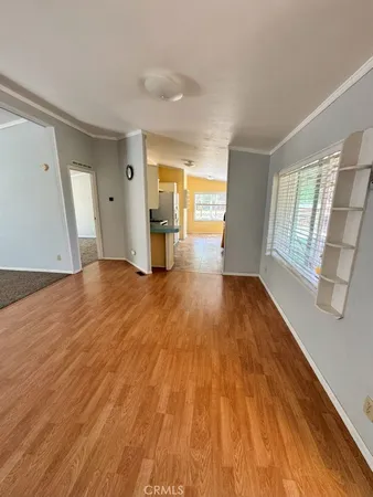 a view of empty room with wooden floor and window
