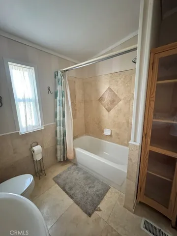 a bathroom with a tub shower sink and vanity