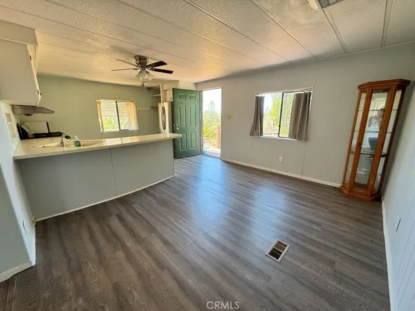 a kitchen with stainless steel appliances granite countertop a stove a sink and white cabinets with wooden floor