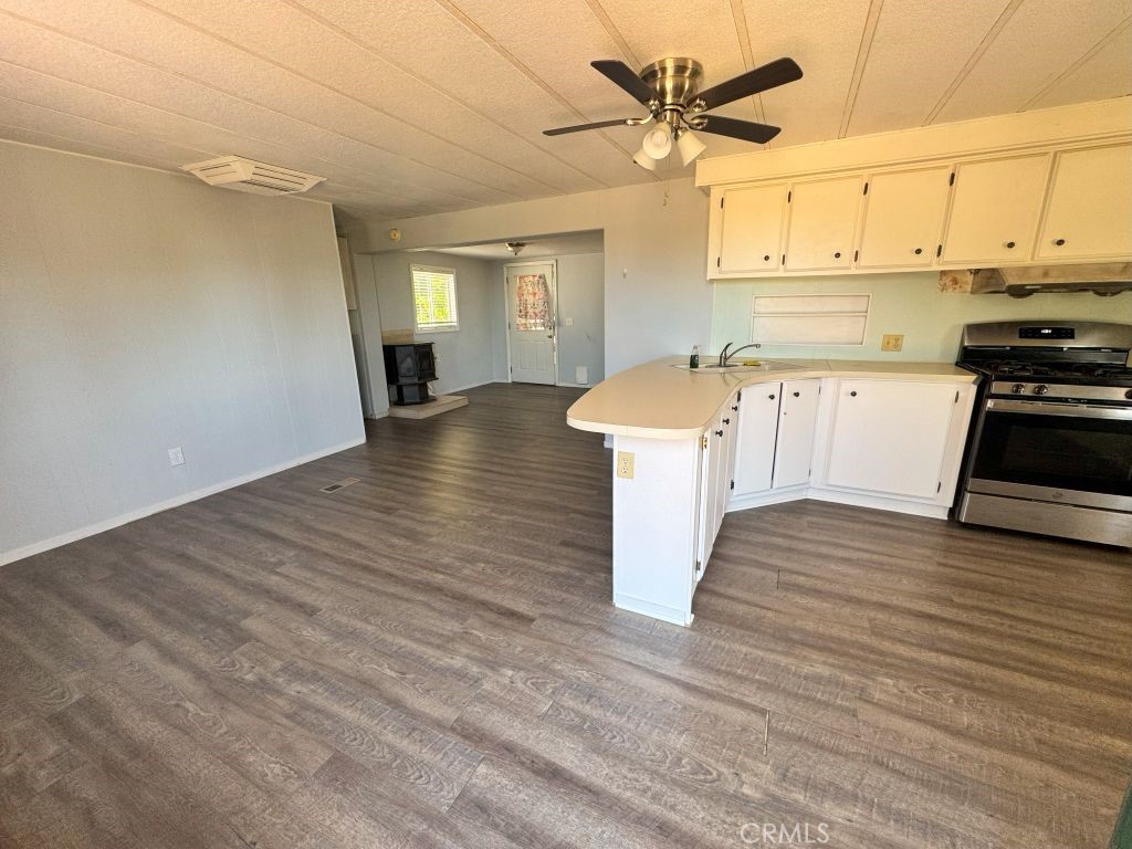 185 Grimont Road Oroville, CA 95966 - Photo 30 of 43 a kitchen with stainless steel appliances granite countertop a stove a sink and white cabinets with wooden floor