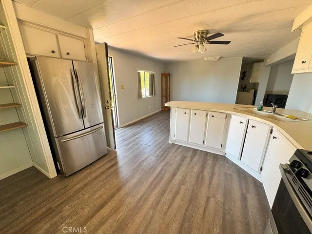 a view of kitchen with sink microwave and window
