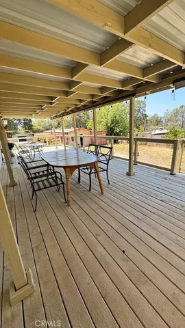 a balcony with wooden floor table and chairs