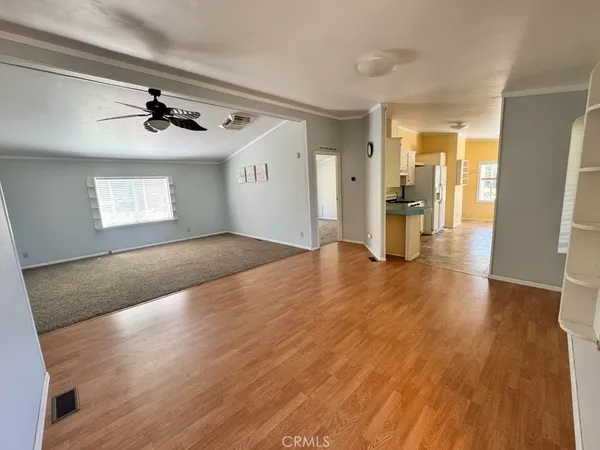 a view of a livingroom with wooden floor and a ceiling fan