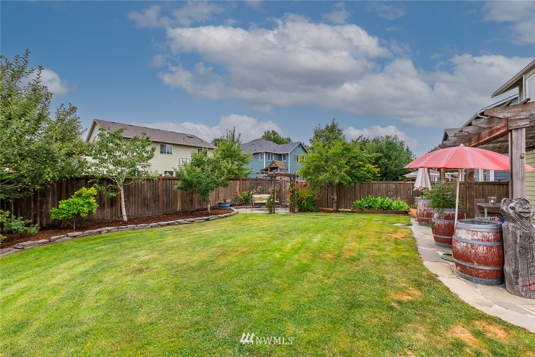 659 Shadow Avenue Northeast Renton, WA 98059 - Photo 30 of 37 a backyard of a house with table and chairs under an umbrella