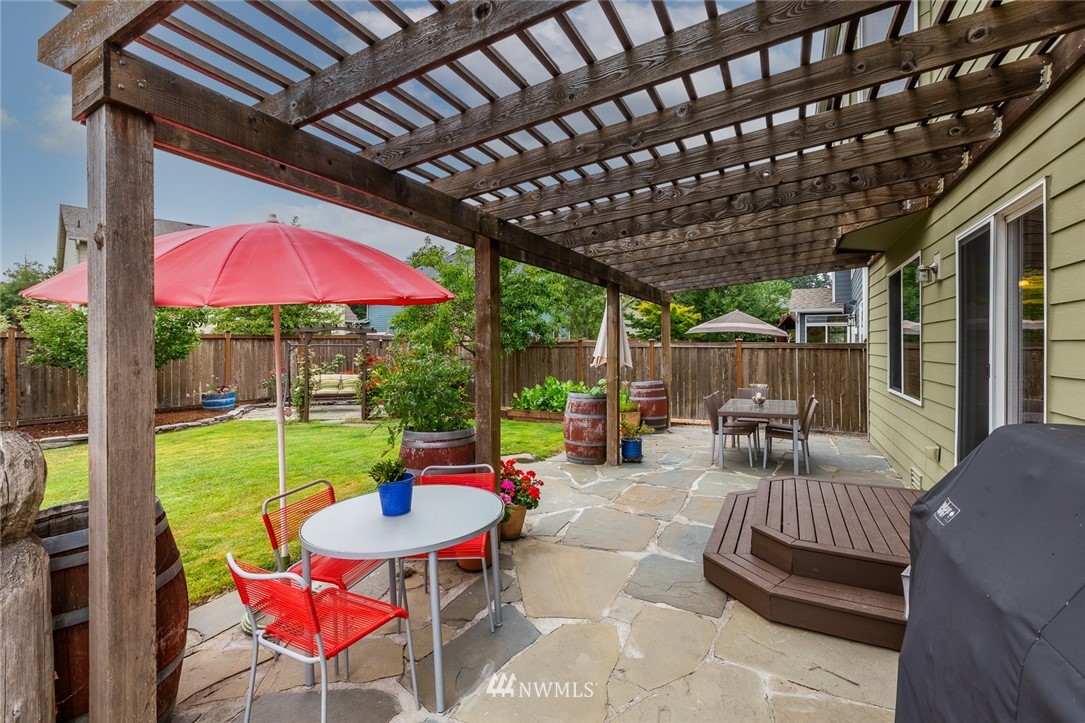 659 Shadow Avenue Northeast Renton, WA 98059 - Photo 31 of 37 a view of a patio with a table chairs and a grill