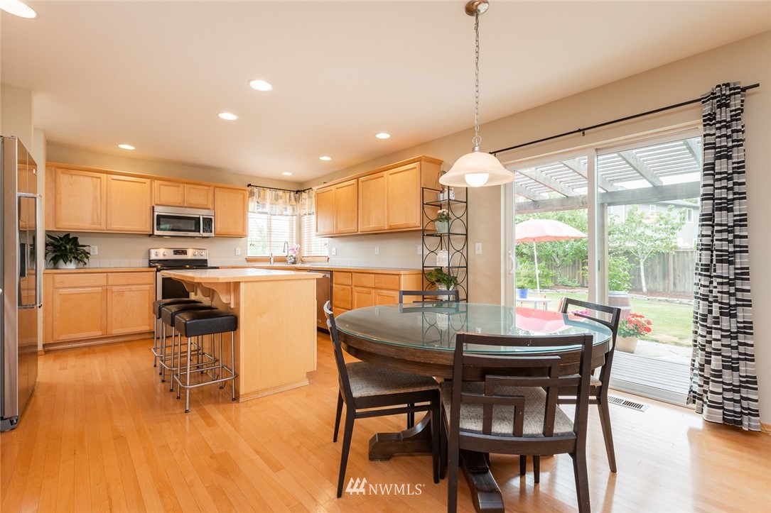 659 Shadow Avenue Northeast Renton, WA 98059 - Photo 8 of 37 a kitchen with a table chairs microwave and cabinets