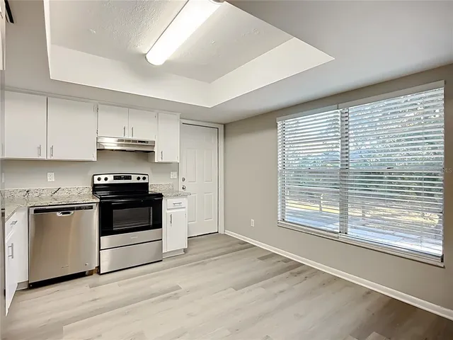 a kitchen with granite countertop a stove a sink and a microwave