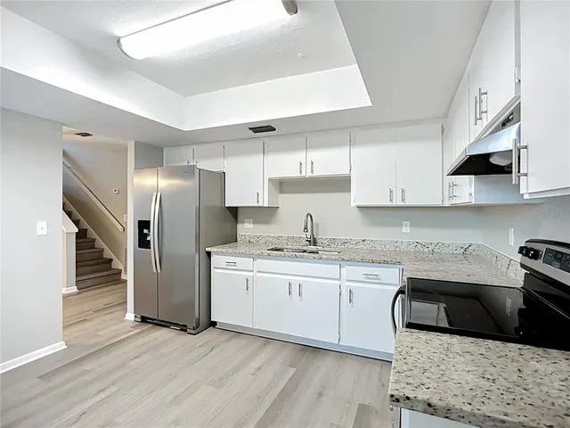 a kitchen with stainless steel appliances granite countertop a sink stove and refrigerator