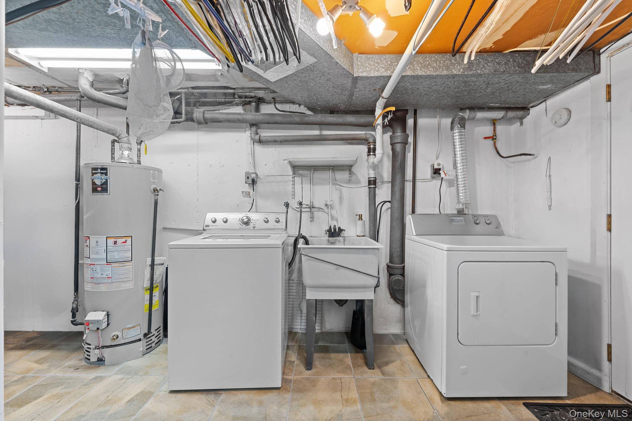 3530 Long Beach Road, Unit 44 Oceanside, NY 11572 - Photo 14 of 17 a utility room with cabinets washer and dryer