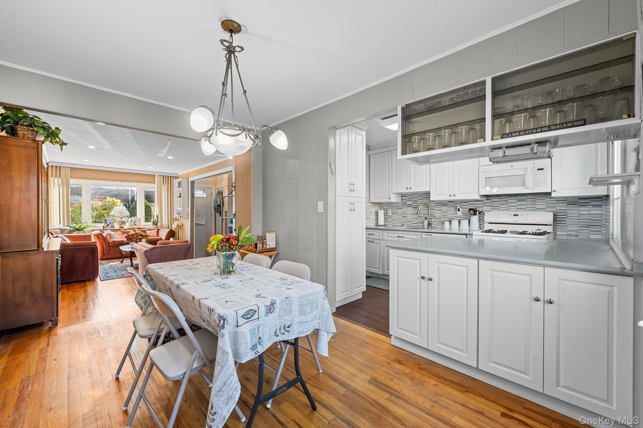 3530 Long Beach Road, Unit 44 Oceanside, NY 11572 - Photo 6 of 17 a kitchen with stainless steel appliances granite countertop a stove a sink dishwasher and white cabinets with wooden floor
