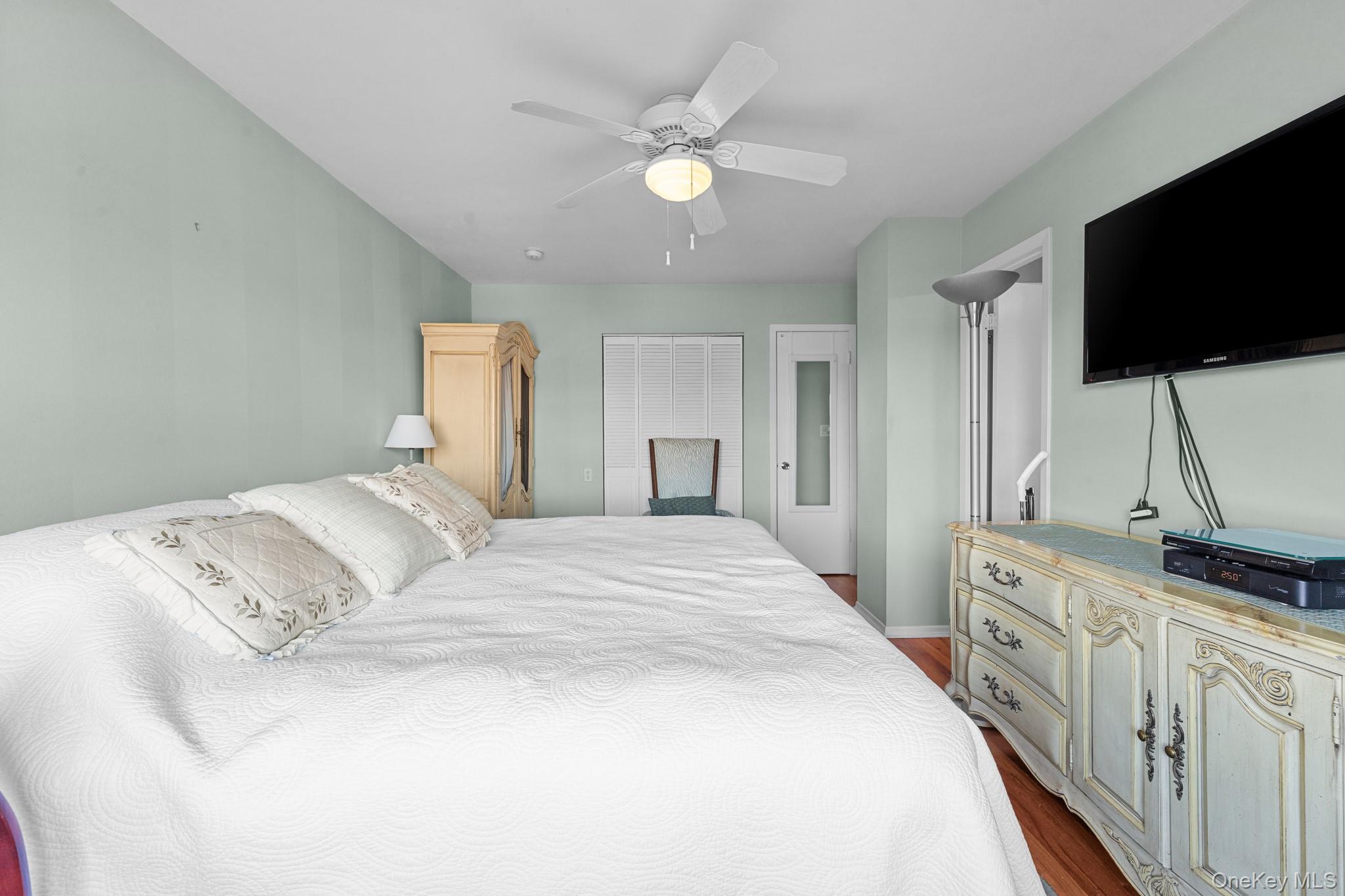 3530 Long Beach Road, Unit 44 Oceanside, NY 11572 - Photo 8 of 17 a spacious bedroom with a bed and a flat screen tv
