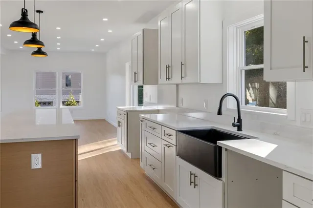a kitchen with a sink white cabinets and appliances
