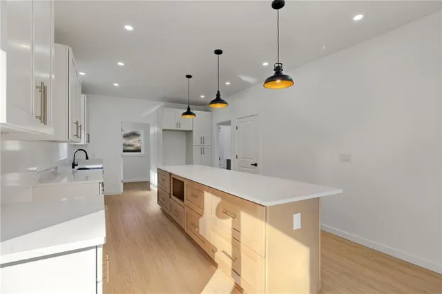 a kitchen with stainless steel appliances granite countertop a sink a stove and a wooden floors