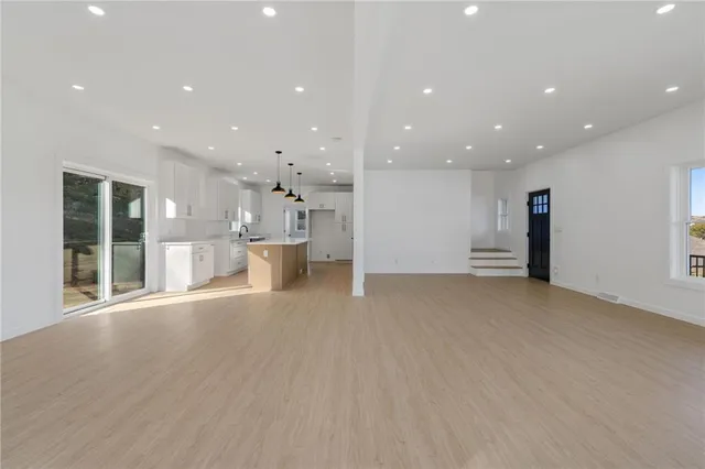a view of a big room with wooden floor and windows
