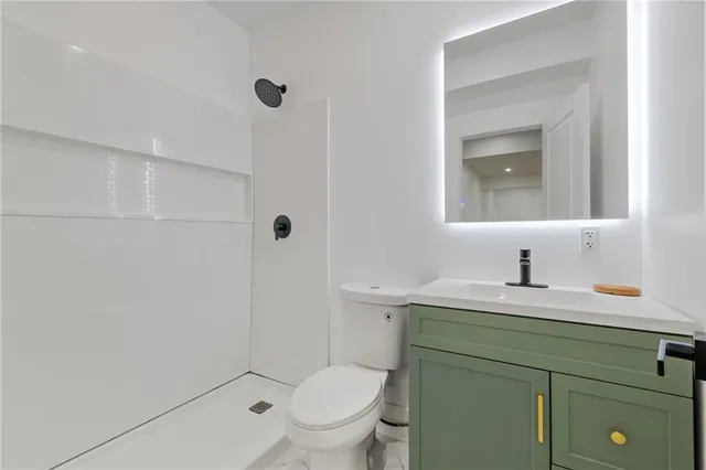 a bathroom with a toilet sink vanity and mirror