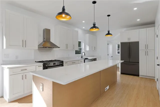 a kitchen with stainless steel appliances granite countertop a sink a stove and a refrigerator