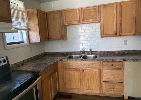 a kitchen with stainless steel appliances granite countertop a sink stove and cabinets