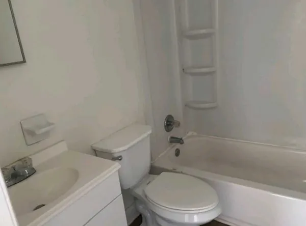 a white toilet and tub sitting next to a bathroom sink