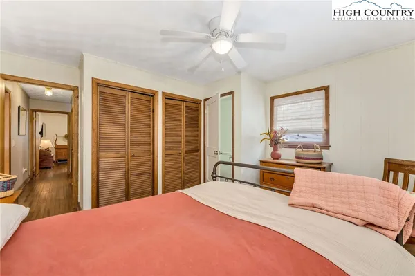 a bedroom with a bed dresser and a large window