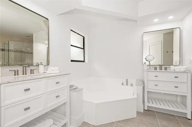 a bathroom with a bathtub sink and mirror