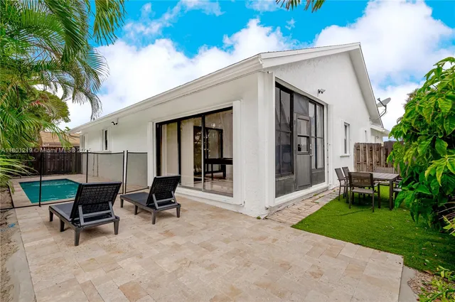 a view of a house with backyard and a sitting area