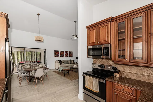 a kitchen with stainless steel appliances granite countertop a stove and a wooden cabinets