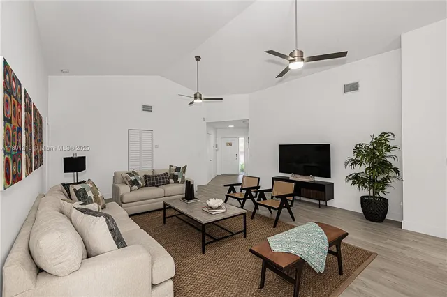 a living room with furniture a chandelier and a flat screen tv