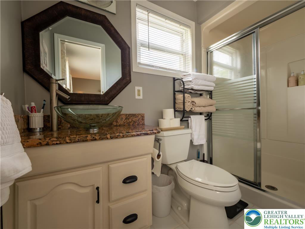 2087 Hopewell Road Bethlehem, PA 18017 - Photo 26 of 38 A well-appointed bathroom features a modern vessel sink, a granite counter, and a glass-enclosed shower.