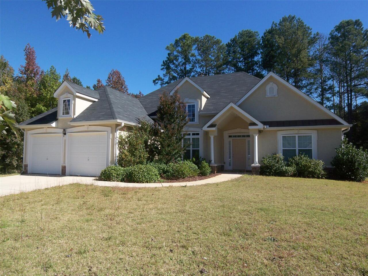 80 Knolls Ridge, Unit 179 Hampton, GA 30228 - Photo 1 of 1 a front view of a house with a yard and garage