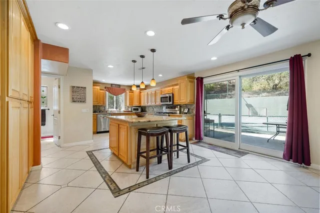 a kitchen with kitchen island granite countertop a stove a sink a refrigerator and a dining table