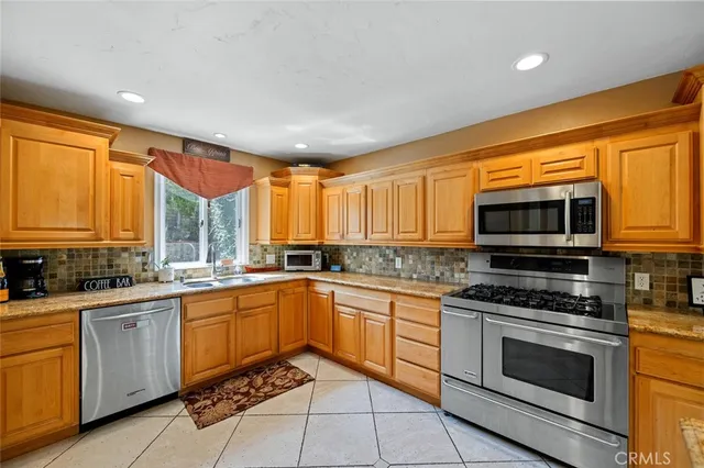 a kitchen with stainless steel appliances a stove sink microwave and cabinets