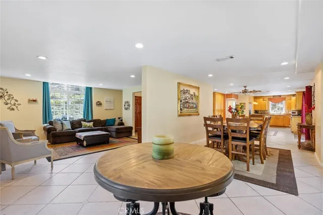 a living room with furniture a table and kitchen view