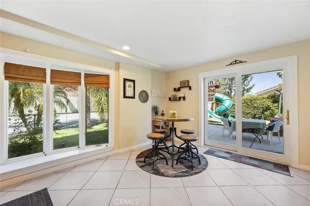 a living room with furniture large window and dining table