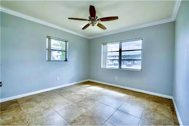 a view of room with ceiling fan and windows