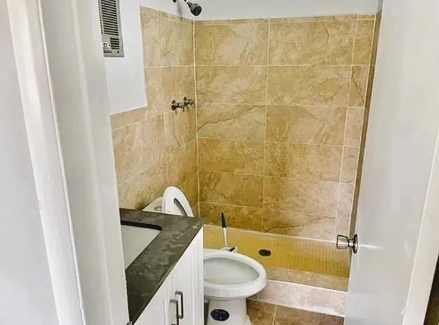a bathroom with a granite countertop bathtub sink mirror vanity and toilet