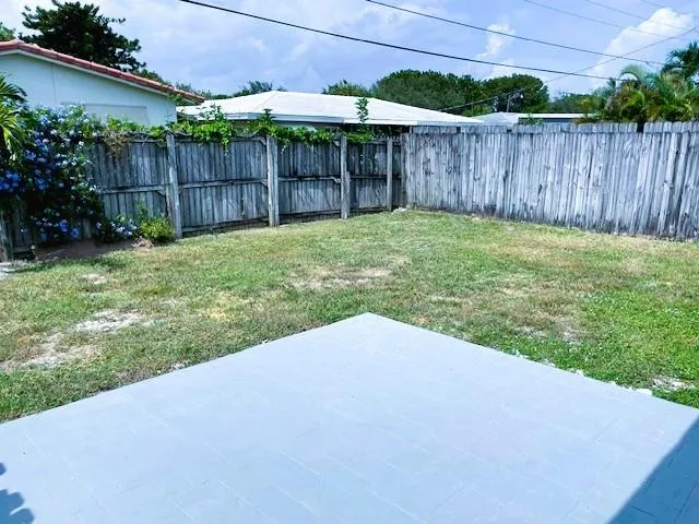 a view of a backyard with potted plants and wooden fence