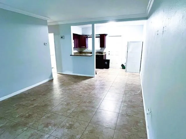 a view of kitchen with granite countertop cabinets and refrigerator